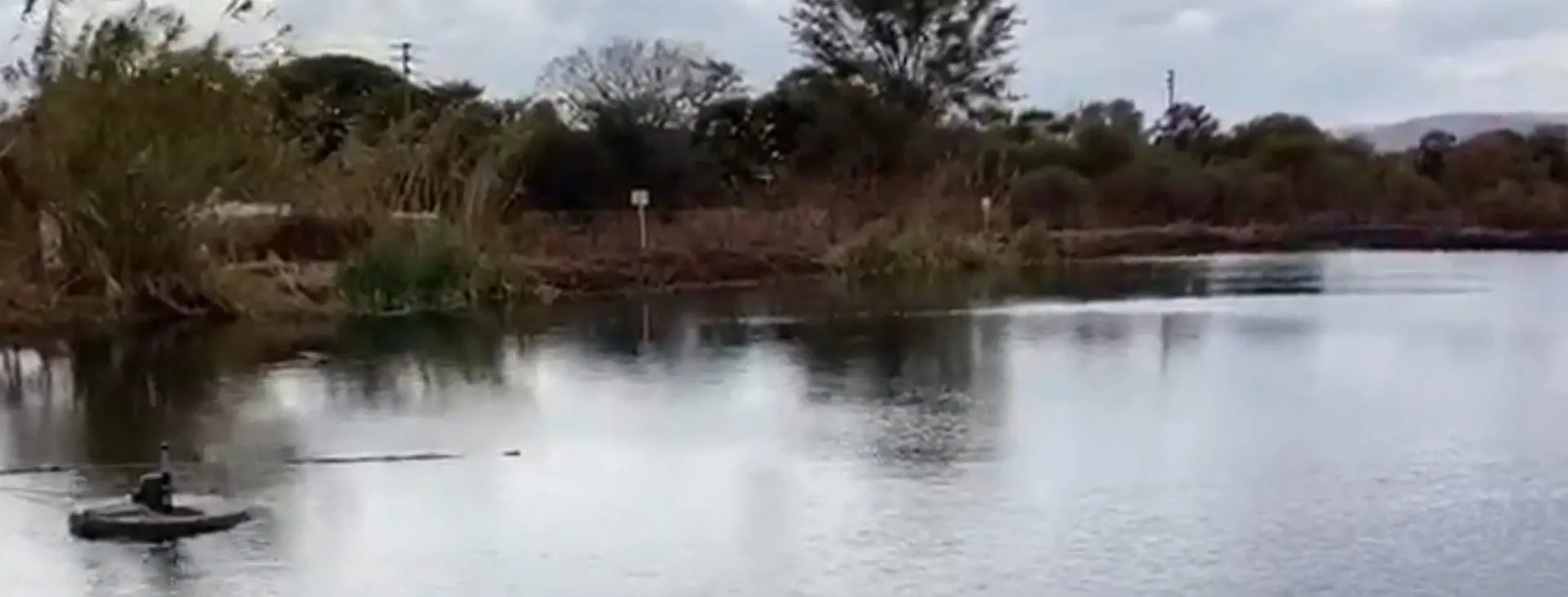 An Axbold Guardian floating at the edge of a treatment pond, aerating the water