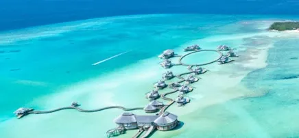 Overwater villas arranged across a shallow tropical lagoon
